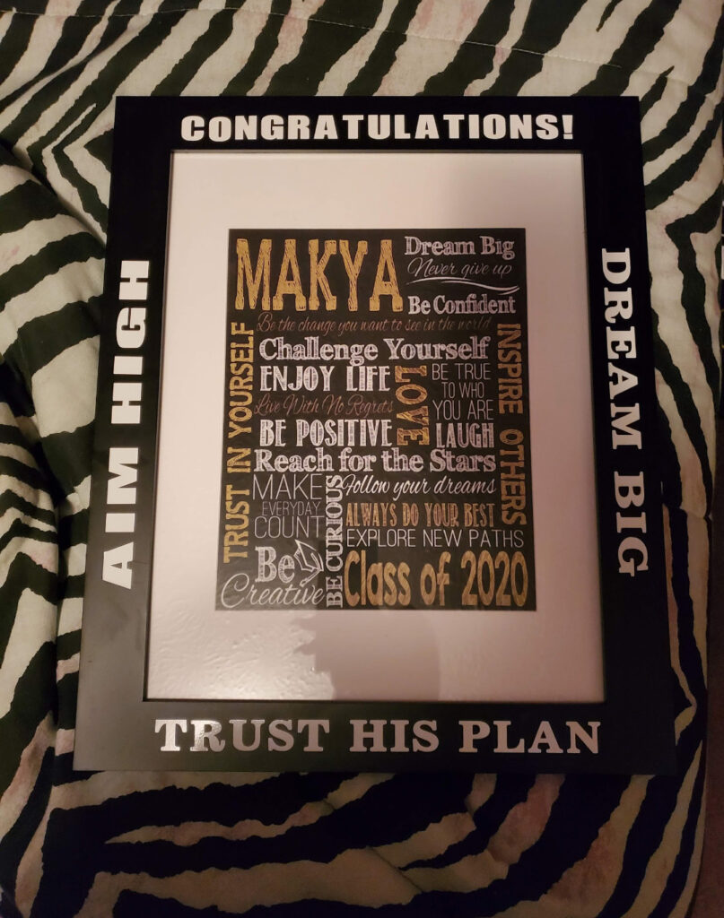 A framed photo with the words "Congratulations!" "Trust His Plan" "Aim High" and "Dream Big" on the frame. The print is a word cloud oof inspirational words and "Class of 2020."